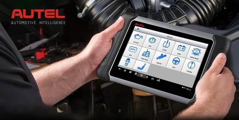 Valise de diagnostic automobile tenue à deux mains, écran affichant les fonctions de diagnostic